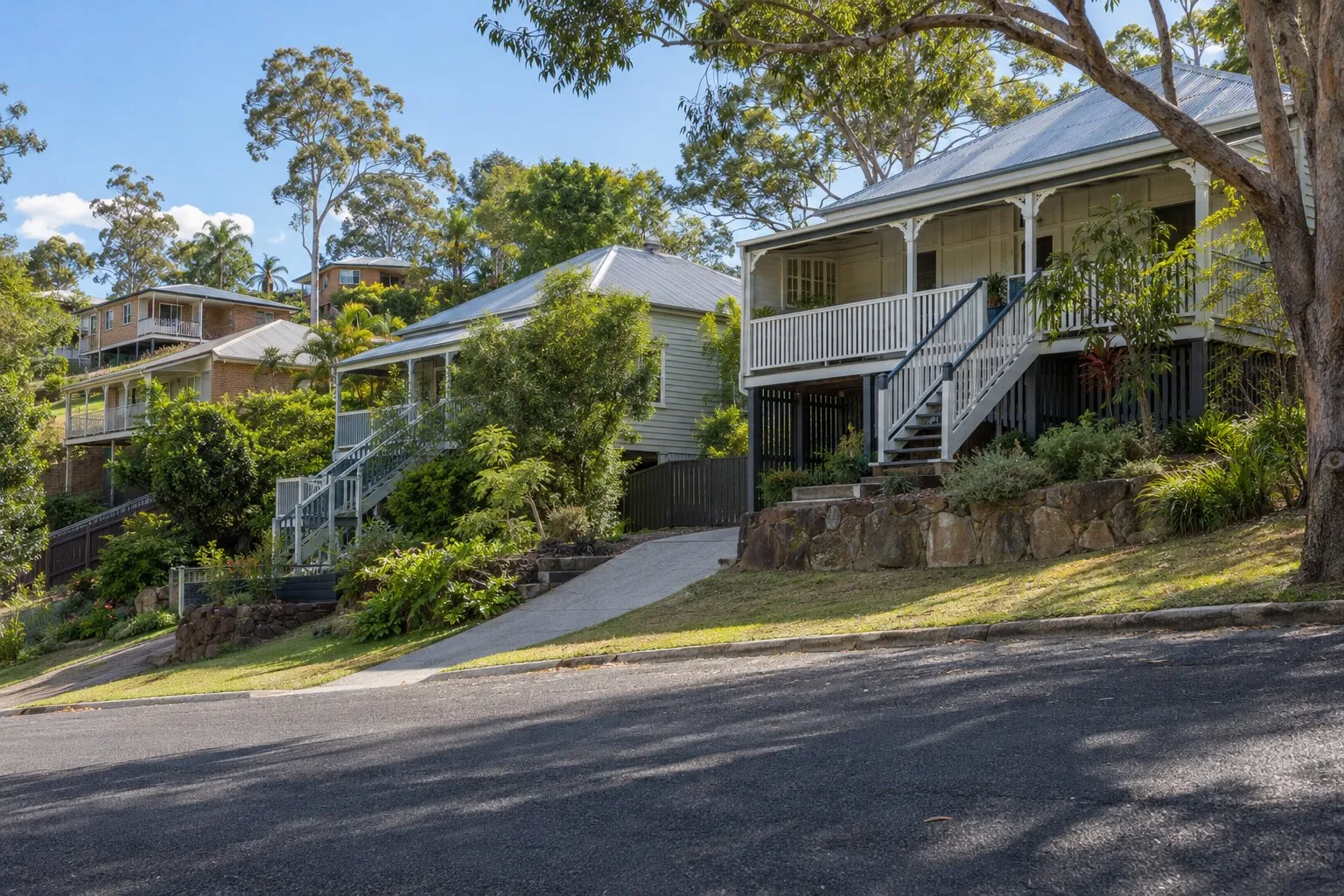 Carpentry, Brisbane: highset timber houses with long front stairs on a hilly western-suburbs street